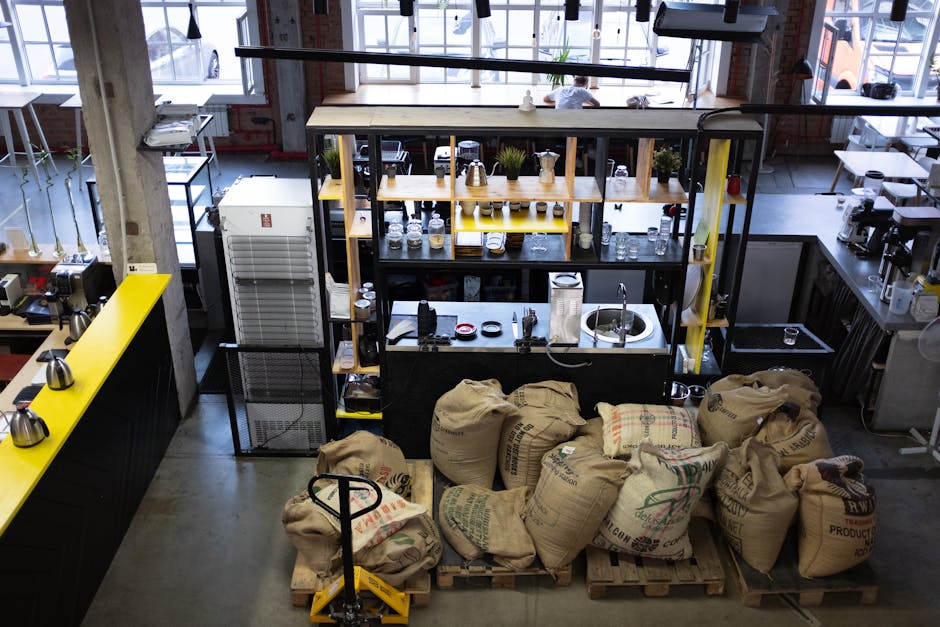 High angle view of a coffee shop interior featuring bean sacks and a well-organized workspace.